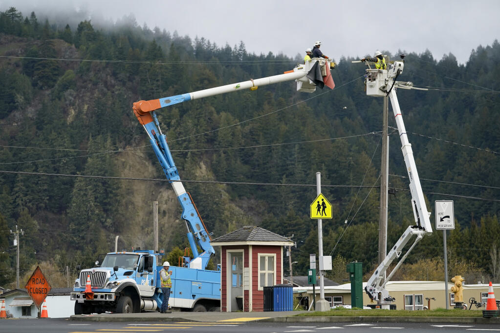 PG&E workers service a power line after an earthquake in Rio Dell on Wednesday, Dec. 21, 2022. Rio Dell is one of three southern Humboldt County cities that faces a problem with more electrical connections to the grid until PG&E completes upgrades to bring a 62% increase in power-supply capacity to the area over the next three years. (AP Photo/Godofredo A. Vásquez)