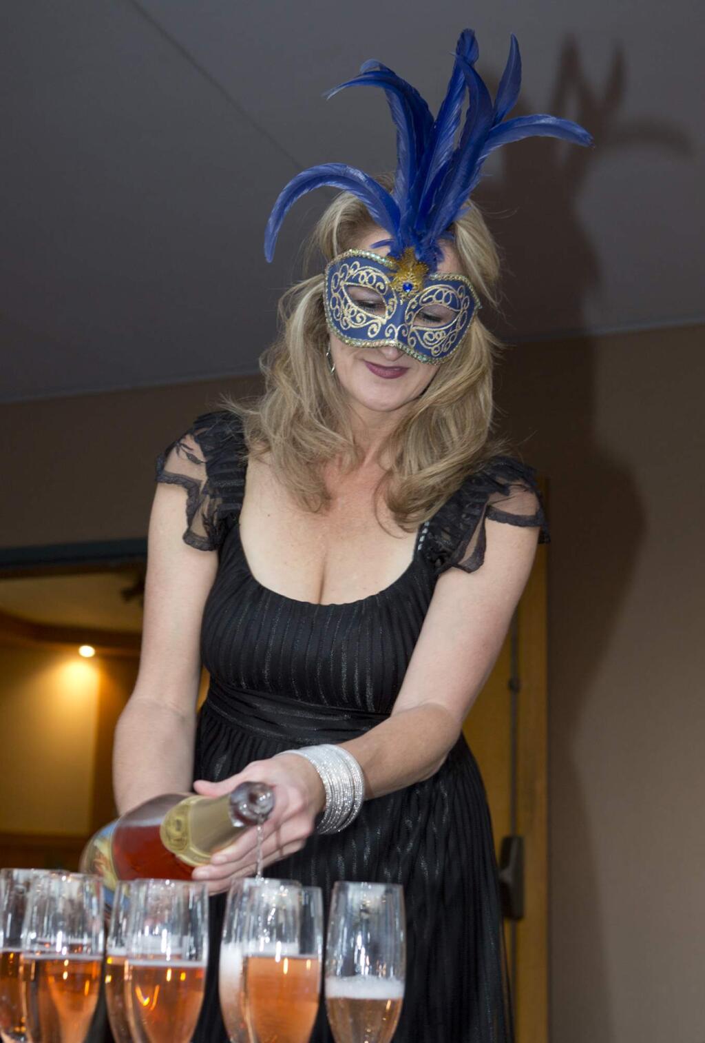 Cynthia Faust from Breathless Wines, pours for guests at the Child Parent Institute Masquerade Ball.
