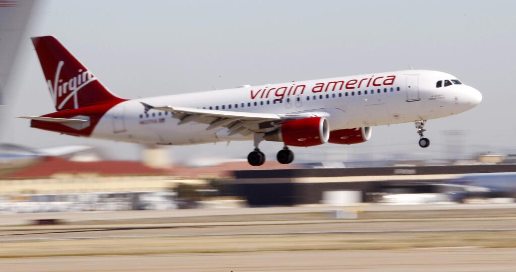 FILE - In this Dec. 1, 2010, file photo, Virgin America's inaugural flight between Los Angeles and Dallas Fort Worth International Airport comes in for a landing in Grapevine, Texas.(AP Photo/LM Otero, File)