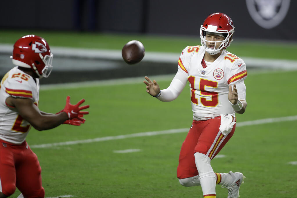Kansas City Chiefs quarterback Patrick Mahomes (15) tosses the ball to running back Clyde Edwards-Helaire (25) during the first half of an NFL football game against the Las Vegas Raiders, Sunday, Nov. 22, 2020, in Las Vegas. (AP Photo/Isaac Brekken)