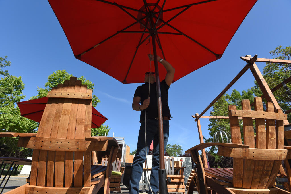 Tranquilino Garcia of Art Barrel Creations sets up his shop at the Windsor Certified Farmers Market in Windsor, Calif. on Sunday May 30, 2021. (Erik Castro / For The Press Democrat)