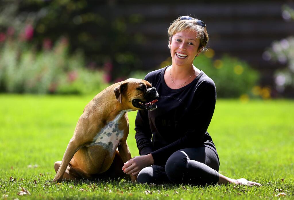 Kaitlyn Hanna was diagnosed with breast cancer in 2015 when she was only 24-years-old. Caitlin plays with her boxer Charlie at her Sonoma home. (John Burgess/The Press Democrat)