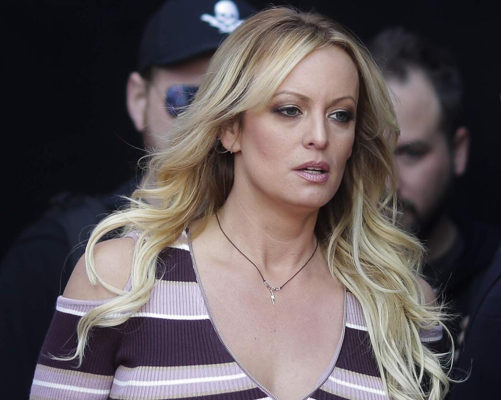 FILE - In this Oct. 11, 2018, file photo, adult film actress Stormy Daniels arrives for the opening of the adult entertainment fair 'Venus,' in Berlin. Attorneys for President Trump want a Los Angeles judge to award $340,000 in legal fees for successfully defending him against defamation claims by Daniels. Attorneys are due in Los Angeles federal court Monday, Dec. 3, to make their case that gamesmanship by Daniels' lawyer led to big bills. (AP Photo/Markus Schreiber, File)