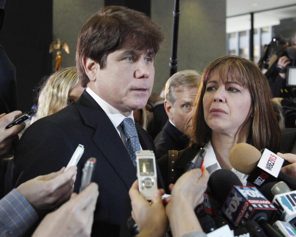 FILE - In this Dec. 7, 2011 file photo, former Illinois Gov. Rod Blagojevich, left, speaks to reporters as his wife, Patti, listens at the federal building in Chicago. President Donald Trump says he is considering commuting the sentence of ex- Gov. Blagojevich and pardoning Martha Stewart. The comments came aboard Air Force One on Thursday, May 31, 2018, after he tweeted that he planned to pardon conservative commentator Dinesh D'Souza. Blagojevich, a Democrat, began serving his 14-year prison sentence on corruption convictions in 2012. (AP Photo/M. Spencer Green, File)
