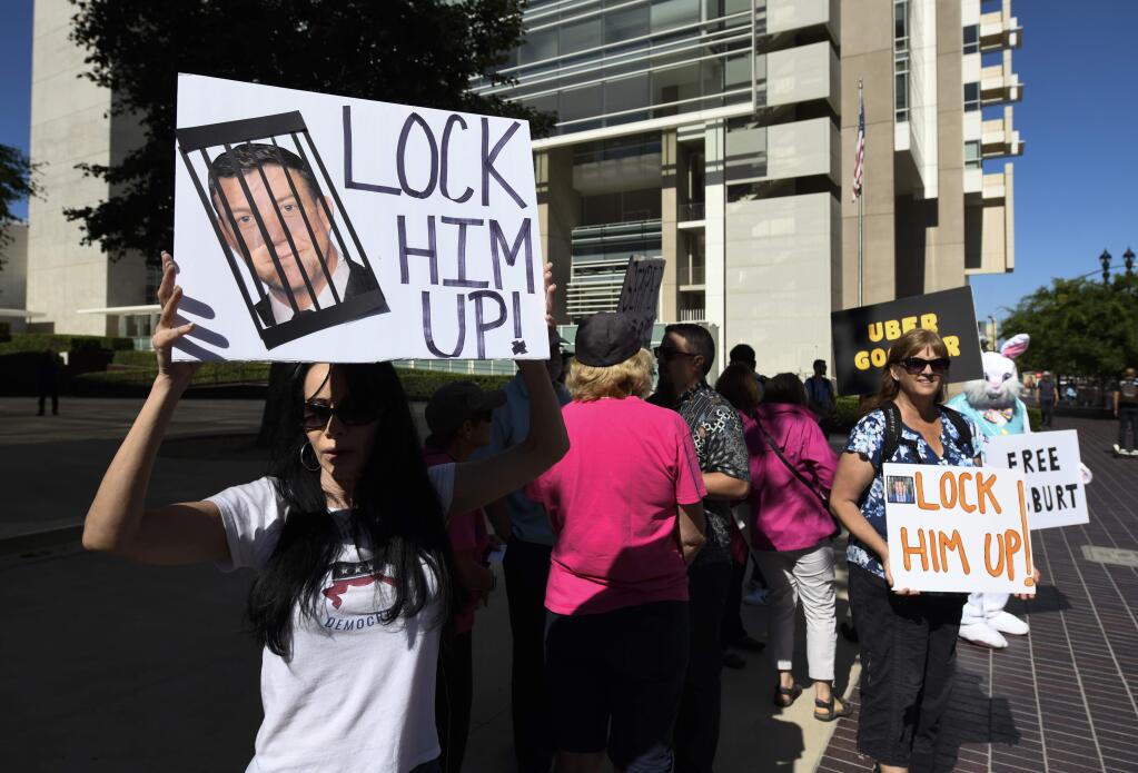 Protesters stand outside of federal court as U.S. Rep. Duncan Hunter, R-Calif., appears for a hearing, Monday, July 1, 2019, in San Diego. Hunter is charged with looting his own campaign cash to finance vacations, golf and other personal expenses, then trying to cover it up. The Republican congressman says he's the target of politically biased prosecutors. (AP Photo/Denis Poroy)