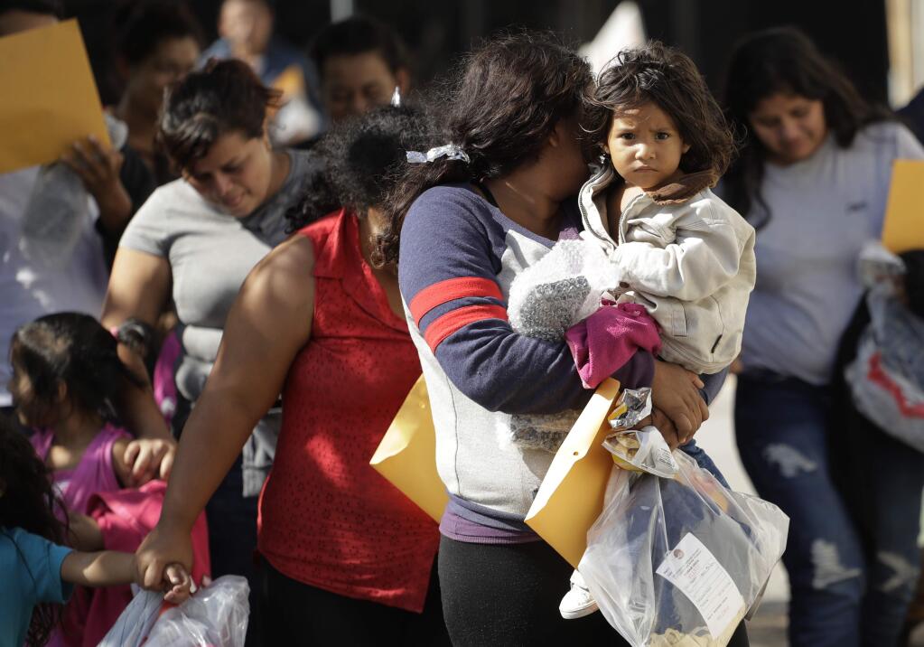 Immigrant families walk to a respite center after they were processed and released by U.S. Customs and Border Protection, Wednesday, June 27, 2018, in McAllen, Texas. (AP Photo/Eric Gay)