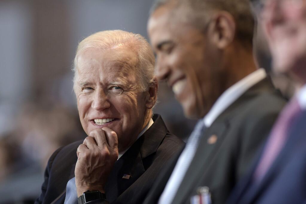 FILE - In this Jan. 4, 2017 file photo, Vice President Joe Biden, left, watches President Barack Obama, center, at Conmy Hall, Joint Base Myer-Henderson Hall, Va. (AP Photo/Susan Walsh)