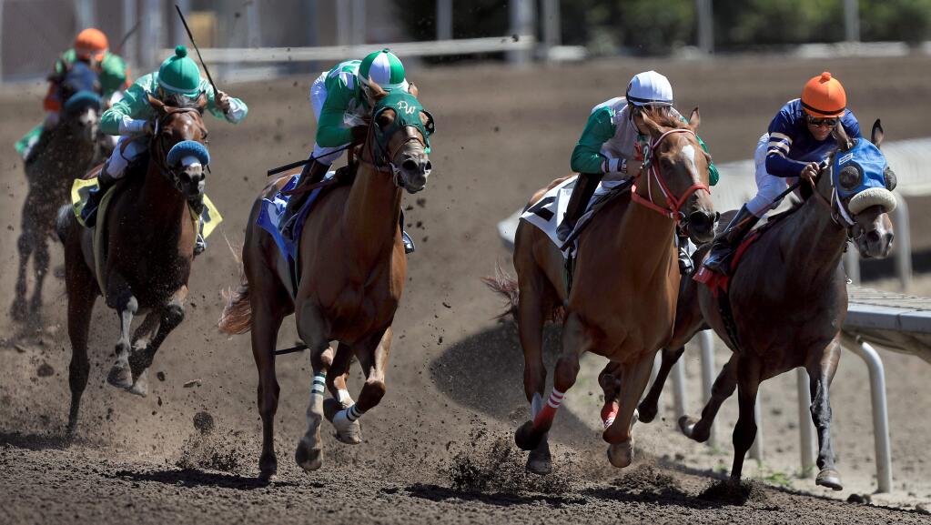 Jockeys and their horses gallop through the last turn on the first day of horse racing on during the Sonoma County Fair in Santa Rosa, Thursday, Aug. 1, 2019. (Kent Porter / The Press Democrat file)