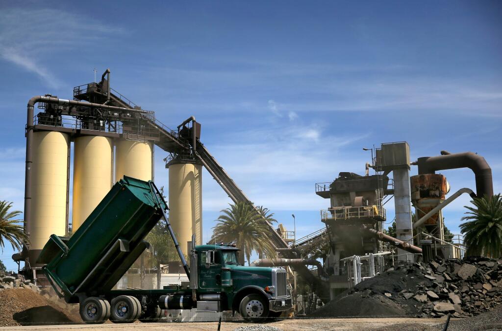 A dump truck unloads dirt and rock on Monday at the BoDean Co. asphalt plant in Santa Rosa. (BETH SCHLANKER / The Press Democrat)