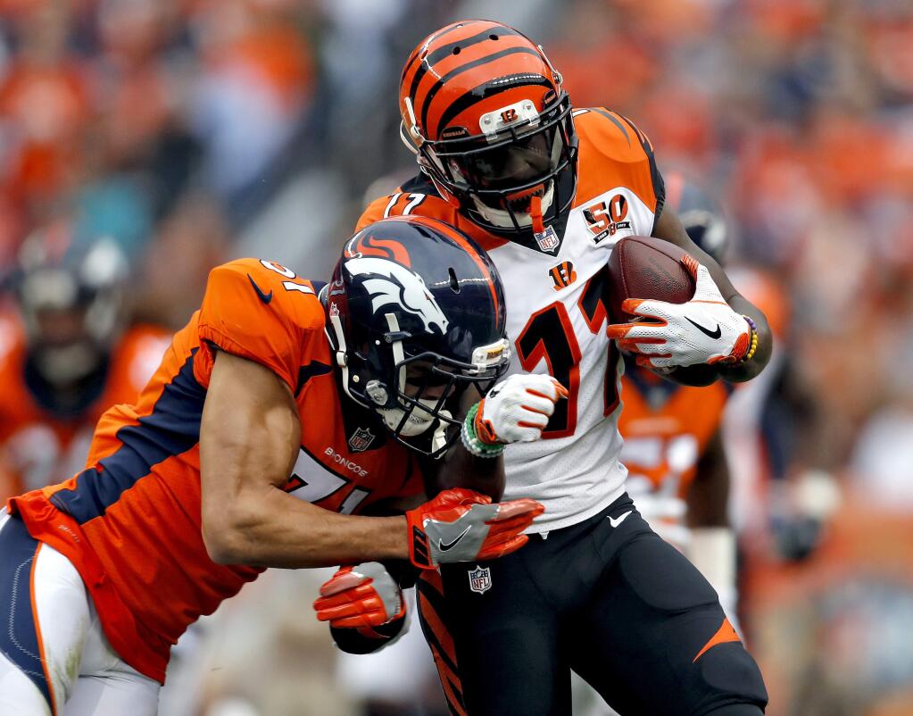 Cincinnati Bengals wide receiver Brandon LaFell is hit by Denver Broncos strong safety Justin Simmons during the first half, Sunday, Nov. 19, 2017, in Denver. (AP Photo/David Zalubowski)