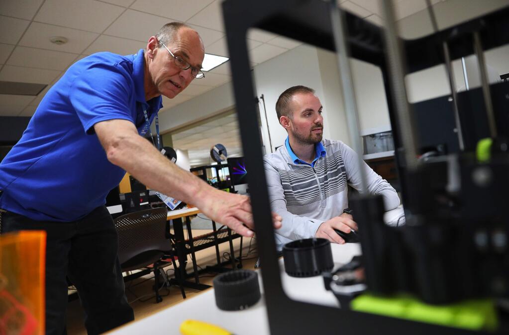Applied physics major Scott Allred, right, works on manufacturing parts for a 600-watt 3D printed DC motor, while equipment technician Steve Anderson examines his progress, during the Science 220: Dream, Make, and Innovate course in the new Makerspace at the SSU Library, in Rohnert Park on Friday, September 29, 2017. (Christopher Chung/ The Press Democrat)