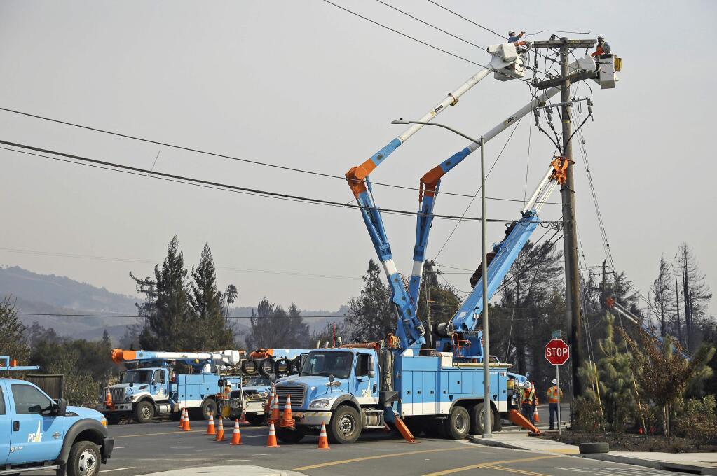FILE - In this Oct. 11, 2017 file photo, a Pacific Gas & Electric crew works at restoring power along the Old Redwood Highway in Santa Rosa, Calif. When California lawmakers return from their summer recess in August 2018, among the high-profile bills they will consider is a measure that would make it easier for utilities to reduce liability for wildfire damage. (AP Photo/Eric Risberg, file)