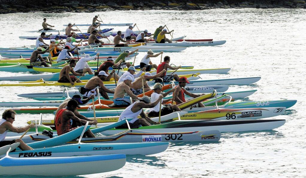 Paddlers at the start of the men's races for one- and two-man outrigger canoes in a recent Queen Lili'uokalani competition at Kailua Pier in Kailua-Kona, Hawaii. (AP Photo/West Hawaii Today, Baron Sekiya)