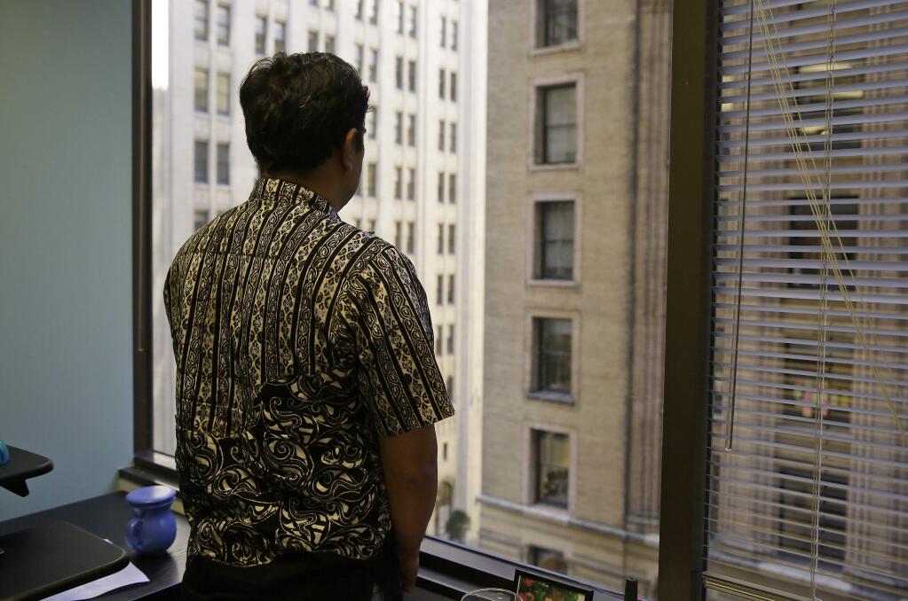 FILE - In this Sept. 22, 2016, file photo, Sorihin, who uses one name, one of two Indonesian fisherman who escaped slavery aboard a U.S.-flagged tuna and swordfish vessel when it docked at San Francisco's Fisherman's Wharf, looks out toward Montgomery Street at the offices of the Legal Aid Society in San Francisco. Attorneys for Sorihin and Abdul Fatah told The Associated Press on Wednesday, Jan. 3, 2018, that they settled their lawsuit against Thoai Van Nguyen, the California-based owner and captain of the Sea Queen II. (AP Photo/Eric Risberg, File)