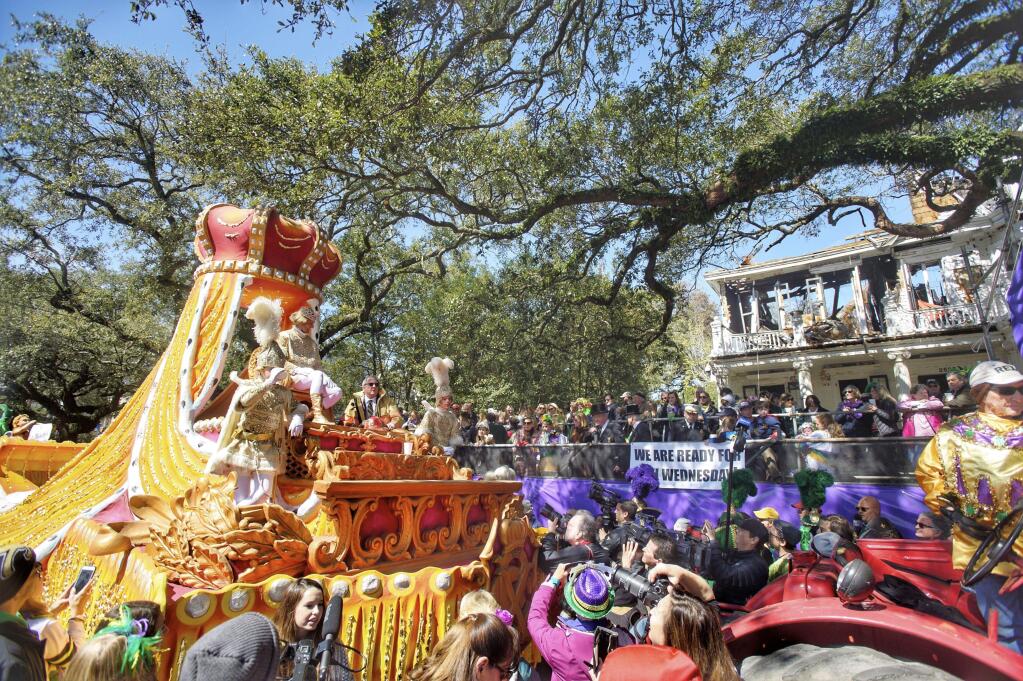 Rex royalty take an extended pause in front of the charred carcass of a St. Charles Avenue mansion to make a toast, carrying on a tradition that began in 1907, at a house that looms large in krewe and Mardi Gras history in New Orleans, Tuesday, March 5, 2019. (Chris Granger/The Advocate via AP)