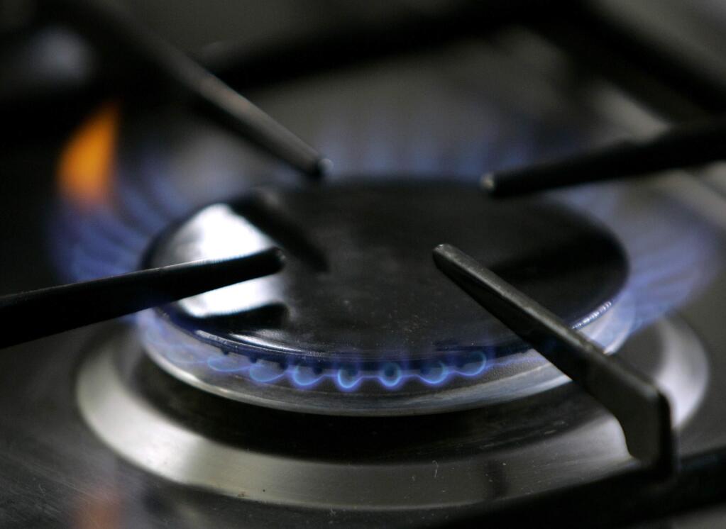 A gas-lit flame burns on a natural gas stove. Napa County staff, in recent weeks, has been studying how to craft a building code to limit or ban natural gas connections in new construction. (AP Photo/Thomas Kienzle, File)