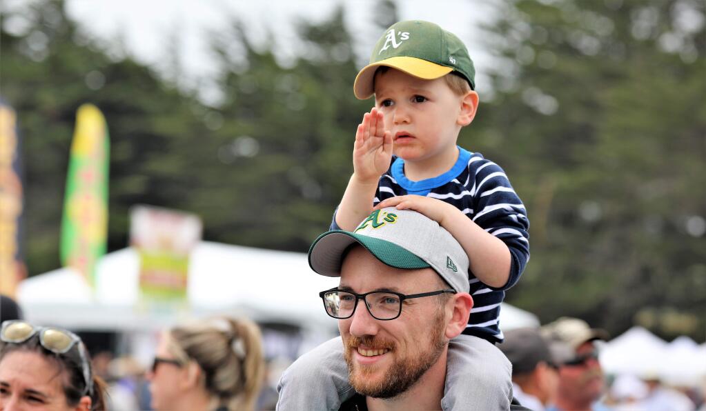 Elliot Breuning, 3, waves to sheriff department personnel with his dad, Drew, at the 46th Annual Bodega Bay Fisherman's Festival at Westside Park in Bodega Bay on Saturday, May 4, 2019. (WILL BUCQUOY/FOR THE PD)