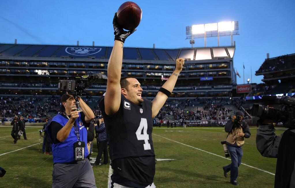Oakland Raiders quarterback Derek Carr celebrates his team's win over the Carolina Panthers in Oakland on Sunday, November 27, 2016. The Raiders defeated the Panthers 35-32.(Christopher Chung/ The Press Democrat)
