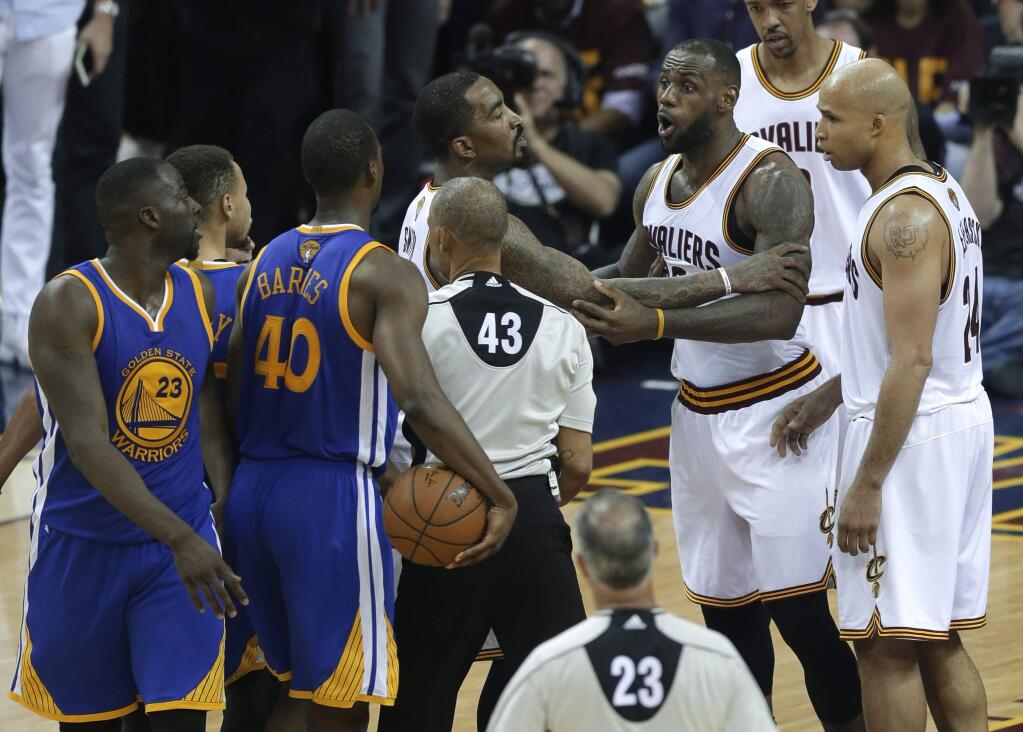 In this June 10, 2016, file photo, Cleveland Cavaliers forward LeBron James (23) is held back as he argues with Golden State Warriors forward Draymond Green (23) during the second half of Game 4 of the NBA Finals in Cleveland. For five months, Green has worked to block out the constant criticism that his Game 5 suspension in the NBA Finals cost Golden State a repeat championship. All for that swipe at LeBron James' groin that swung the series for Cleveland. (AP Photo/Tony Dejak, File)