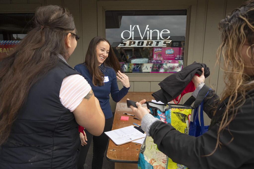 From left, Martha Solorio, Corazon Healdsburg CEO Ariel Kelley and Rochelle Kelly check the sizes on donated tops at the opening of Healdsburg Free Store on Thursday, Nov. 21, 2019. (John Burgess/The Press Democrat)