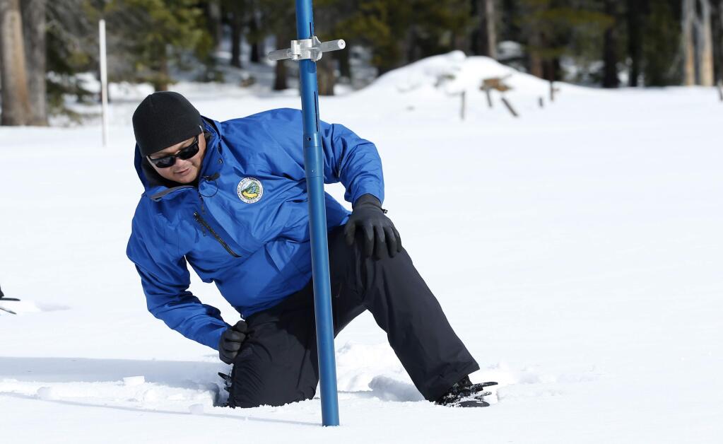 Sean de Guzman, chief of snow surveys for the California Department of Water Resources, checks the depth of the snowpack during the first snow survey of the season at Phillips Station near Echo Summit, Calif., Thursday, Jan. 2, 2020. The survey found the snowpack at 33.5 inches deep with a water content of 11 inches which is 97% of average at this location at this time of year. (AP Photo/Rich Pedroncelli)