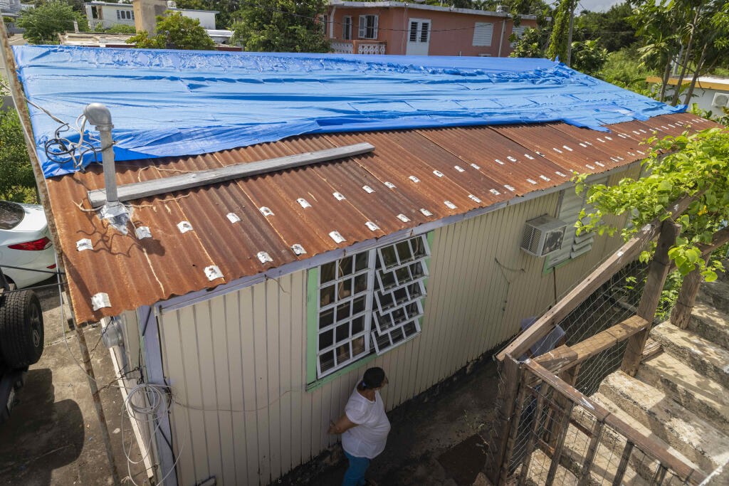 Virmisa Rivera stands outside or home damaged by Hurricane Maria nearly five years ago, in Loiza, Puerto Rico, Thursday, Sept. 15, 2022. “My house is falling apart,” she said, adding that the government said it would move her to a new home in another neighborhood since they can’t repair hers because it’s in a flood zone. But Rivera worries she will die if she moves: She takes medication day and uses an oxygen tank. Her family lives next door, which gives her security since she now lives alone. (AP Photo/Alejandro Granadillo)
