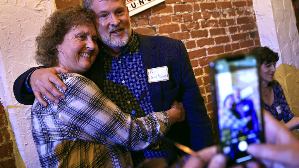 At a book release for “Inflamed” writer Paul Gullixson, right, has his picture taken with Elizabeth Cobb-Bruno, the former activities director of Villa Capri. At far right is co-author Anne Belden. The authors were greeted with a full venue at Barrel Proof Lounge in Santa Rosa, Thursday, Nov. 2, 2023.  (Kent Porter / The Press Democrat)
