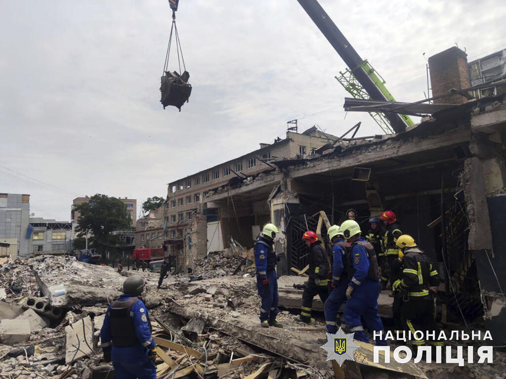 In this photo provided by the National Police of Ukraine, emergency services work near to a restaurant RIA Pizza destroyed by a Russian attack in Kramatorsk, Ukraine, Wednesday, June 28, 2023. (National Police of Ukraine via AP)