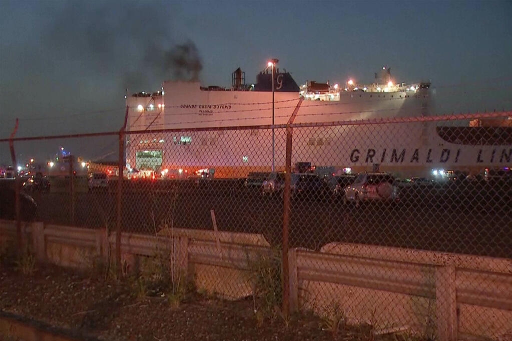 In this image taken from video, smoke rises from a cargo ship early Thursday, July 6, 2023, in the port of Newark, New Jersey. Two firefighters were killed battling the blaze that began when cars caught fire deep inside the ship carrying 1,200 cars at the port, Newark's fire chief said. (WABC-TV via AP)