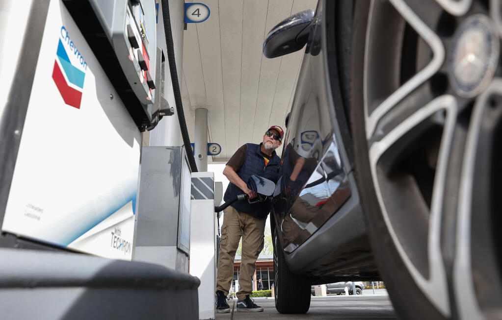 Harold Illg looks at the pump while filling his gas tank at a Chevron gas station along Mendocino Avenue in Santa Rosa, Wednesday, April 17, 2024. (Christopher Chung / The Press Democrat)
