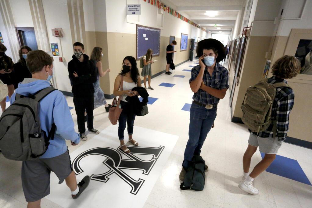 Students wait in line for the office while others walk to class during the first day at West County High School, on the former Analy High School campus, in Sebastopol, Calif., on Thursday, August 12, 2021.(Beth Schlanker/The Press Democrat)