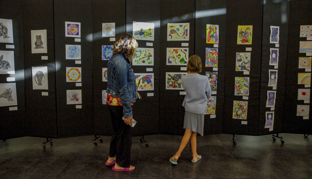 Caitlin Meredith walks through the Petaluma City Schools’ art exhibit with her daughter, Saralena. The PCS annual art showcase, “The Heart of us”  took place at the Community Center in Lucchesi Park on Wednesday, May 01 2024. (CRISSY PASCUAL/ARGUS-COURIER STAFF)