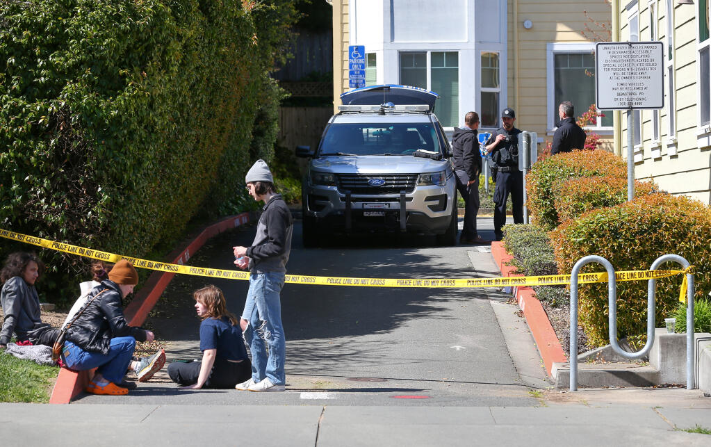 Sebastopol Police and Sonoma County District Attorney’s Office investigators examine a crime scene in the 500 block of South Main Street in Sebastopol, as members of the gather on the sidewalk, Wednesday, April 12, 2023.  (Christopher Chung / The Press Democrat)