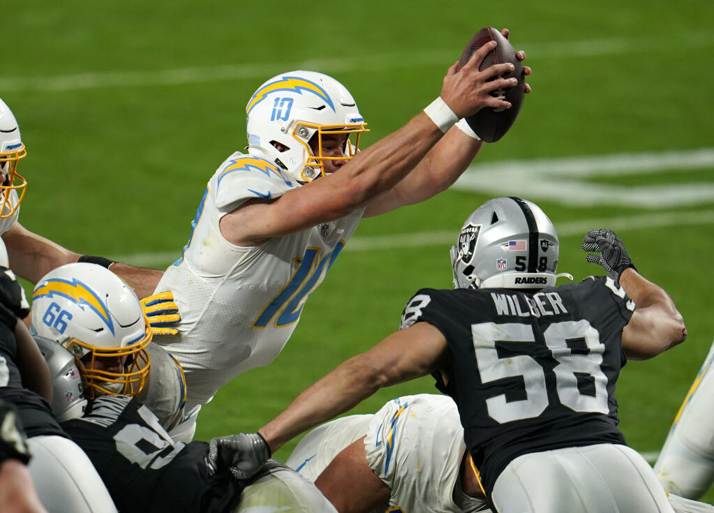 Los Angeles Chargers quarterback Justin Herbert scores the game-winning touchdown in overtime against the Las Vegas Raiders on Thursday, Dec. 17, 2020. (Jeff Bottari / ASSOCIATED PRESS)