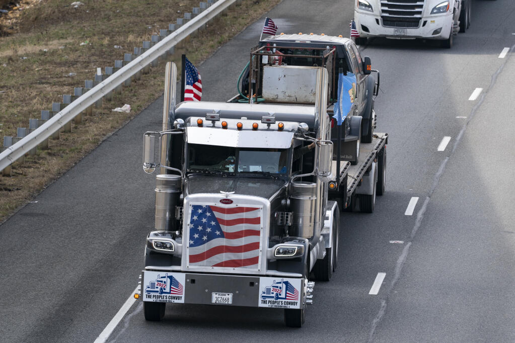 A convoy of trucks and other vehicles travels the I-495 Capital Beltway near the Woodrow Wilson Bridge, to protest mandates and other issues, Sunday, March, 6, 2022, in Fort Washington, Md. (AP Photo/Alex Brandon)