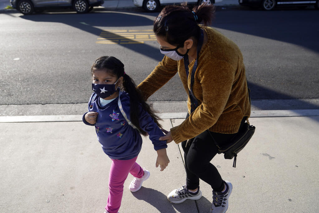 A student is dropped off at Newhall Elementary School Thursday, Feb. 25, 2021, in Santa Clarita, Calif. Elementary school students returned to school this week in the Newhall School District. (AP Photo/Marcio Jose Sanchez)