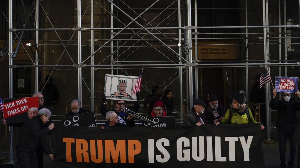 People protest in front of the District Attorney office ahead of former President Donald Trump's anticipated indictment on Tuesday, March 21, 2023, in New York.   A New York grand jury investigating Trump over a hush money payment to a porn star appears poised to complete its work soon as law enforcement officials make preparations for possible unrest in the event of an indictment.(AP Photo/Eduardo Munoz Alvarez)