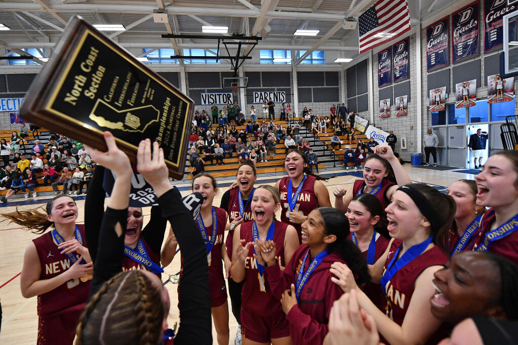 Cardinal Newman players celebrate with the first place plaque after defeating San Ramon Valley during their NCS Open Division Championship game at Dublin High School in Dublin on Saturday, Feb. 24, 2024. Cardinal Newman defeated San Ramon Valley 61-55. (Jose Carlos Fajardo/Bay Area News Group)