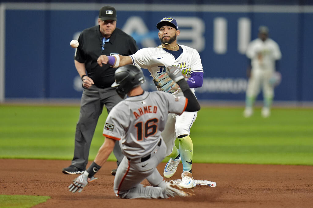 Tampa Bay Rays shortstop José Caballero forces the Giants’ Nick Ahmed at second base and relays the throw to first in time to turn a double play on Jung Hoo Lee during the fifth inning Friday in St. Petersburg, Florida. (Chris O’Meara / ASSOCIATED PRESS)