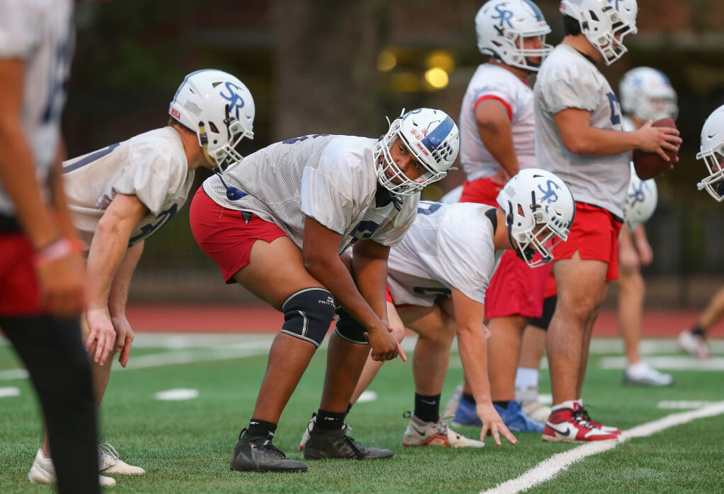 SRJC offensive lineman Dodji Dahoue, center, checks in with a teammate as they line up in position during practice in Santa Rosa on Thursday, Nov. 2, 2023. (Christopher Chung / The Press Democrat)
