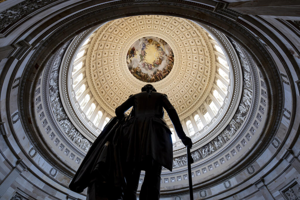 The Rotunda of the U.S. Capitol Building is seen with a statue of George Washington in the foreground, in Washington, Wednesday, May 17, 2023. President Joe Biden and Speaker of the House Kevin McCarthy, R-Calif., have tasked a handful of representatives to work out a final deal on the debt limit. (AP Photo/J. Scott Applewhite)