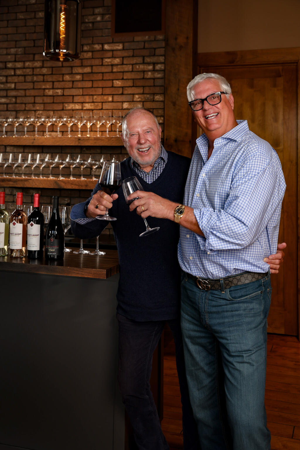 Phil Hurst, right, raises a glass of Truett Hurst wine with Ken Wilson in the tasting room, which is set to open at 113 Mill St. in Healdsburg in early April. (Will Bucquoy Photography)