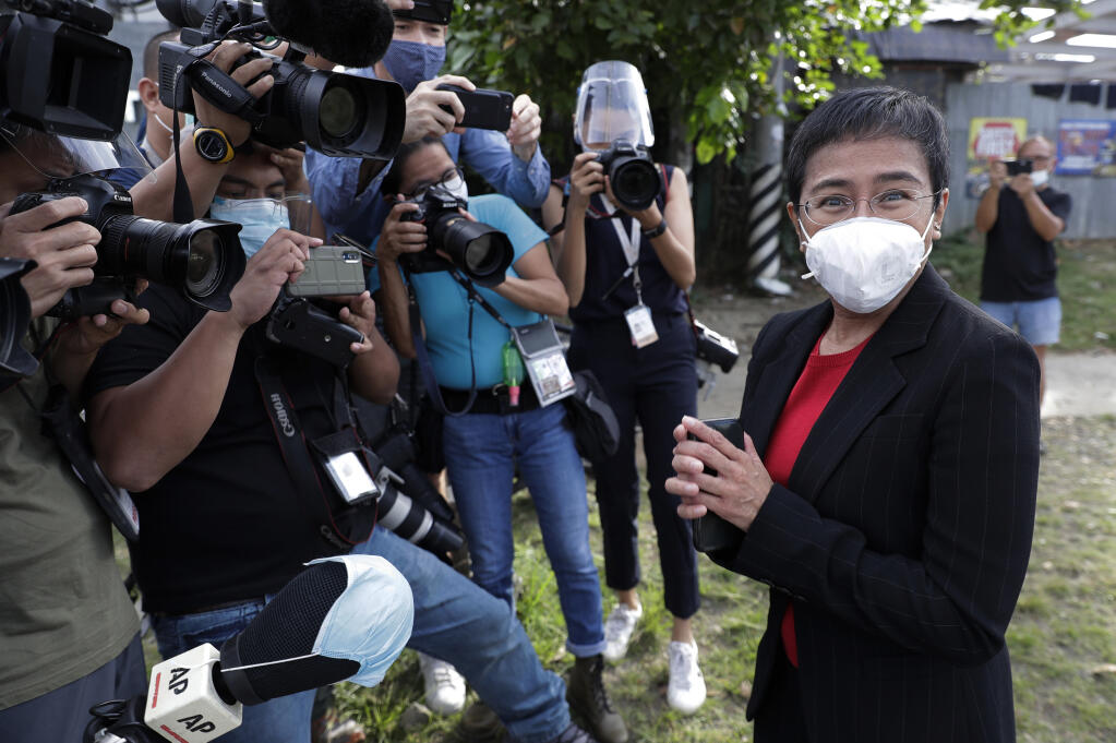 FILE - In this March 4, 2021, file photo, Rappler CEO and Executive Editor Maria Ressa, right, wearing a face mask to prevent the spread of the coronavirus, stands in front of reporters as she arrives at the Court of Tax Appeals in Metro Manila, Philippines. The Nobel Peace Prize was awarded to journalists Ressa of the Philippines and Dmitry Muratov of Russia for their fight for freedom of expression. (AP Photo/Aaron Favila, File)