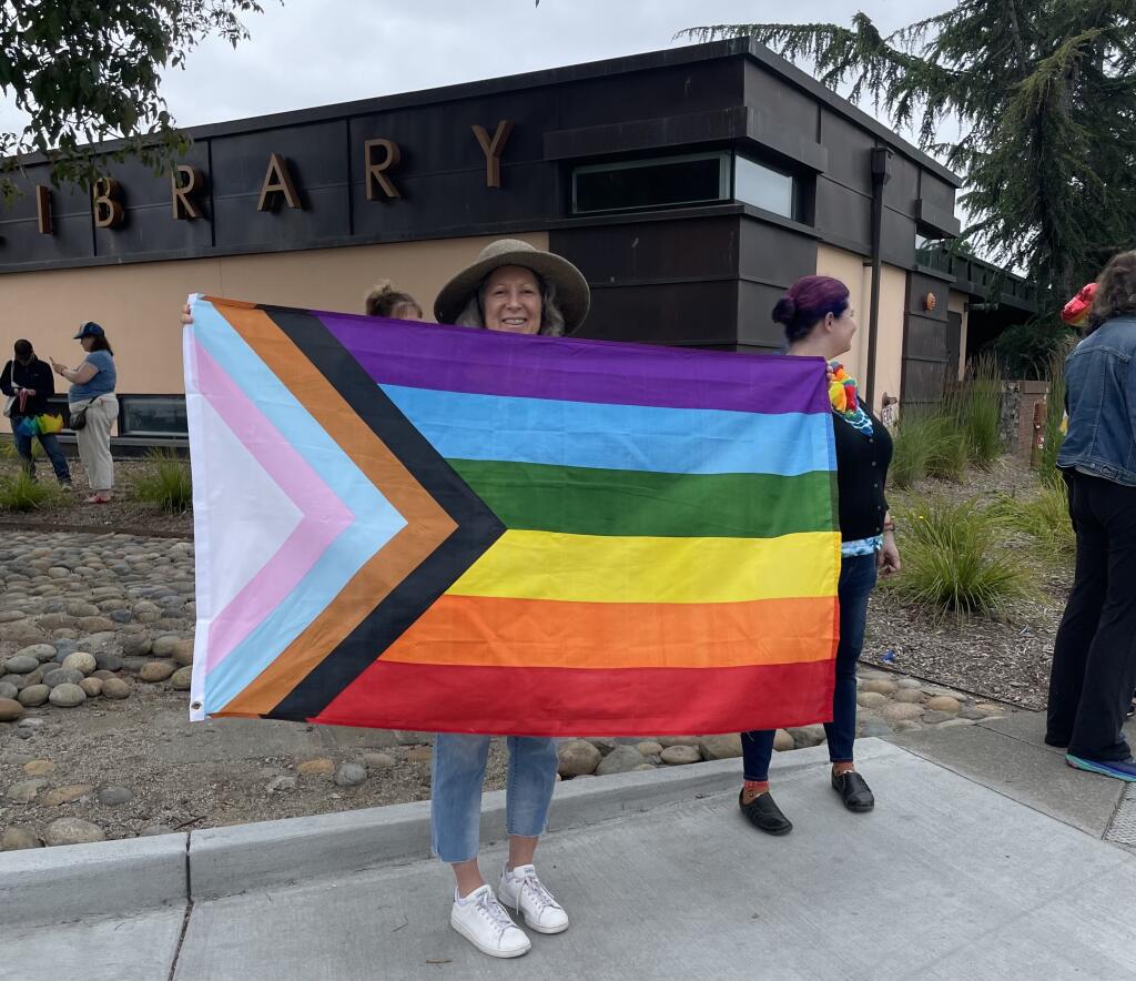 Jodi Boyle from Unitarian Universalists of Petaluma holds a Pride flag on Saturday June 10, 2023 outside of the Petaluma Regional Library. (Jennifer Sawhney / The Press Democrat)