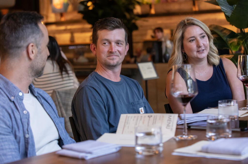 Three millennials, seated from left, Zach Permutt, Ben Burwell and Siena Burwell spent a night talking opinions on wine with Press Democrat wine writer Peg Melnik at The Matheson while exploring the restaurant’s wine wall and parings in downtown Healdsburg, Wednesday June 28, 2023. (Chad Surmick / The Press Democrat)
