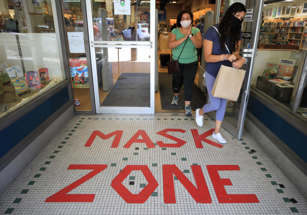 Camila Gonzalez and her mother Diana of Petaluma leave Copperfield's Bookstore in May 2021. Sonoma County lifted its indoor mask mandate in February of this year, and the “mask zone” sign has since been removed. (Kent Porter/The Press Democrat)