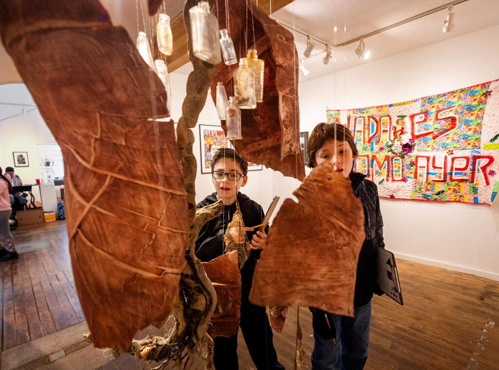Riviera Elementary School students Sawyer Post, 9, left, and Thomas Bond, 10, look for repeating patterns in pieces on display in the Raices Hermosas “Gorgeous Roots” exhibit by Latinx artists at the Middletown Art Center Thursday, Feb. 29, 2024. (John Burgess / The Press Democrat)