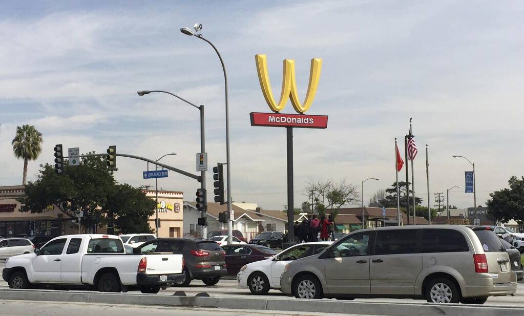 A McDonald's restaurant displays a flipped Golden Arches sign March 8, 2018, in Lynwood, California. The restaurant chain temporarily flipped its famous Golden Arches to look like a "W," a move it says it made to recognize International Women's Day. (AP Photo/Amanda Myers)