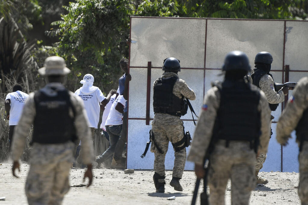 Supporters of slain Haitian President Jovenel Moise are blocked by security forces from attending Moise's funeral outside the former leader's family home in Cap-Haitien, Haiti, Friday, July 23, 2021. Moise was assassinated at his home in Port-au-Prince on July 7. (AP Photo/Matias Delacroix)