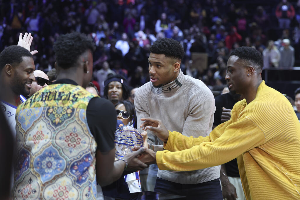 The Milwaukee Bucks’ Giannis Antetokounmpo, center, along with brothers Thanasis Antetokounmpo, right, and Alex Antetokounmpo, award NFL player DK Metcalf the MVP award at the NBA All-Star Celebrity Game on Friday, Feb. 17, 2023, in Salt Lake City. (Rob Gray / ASSOCIATED PRESS)